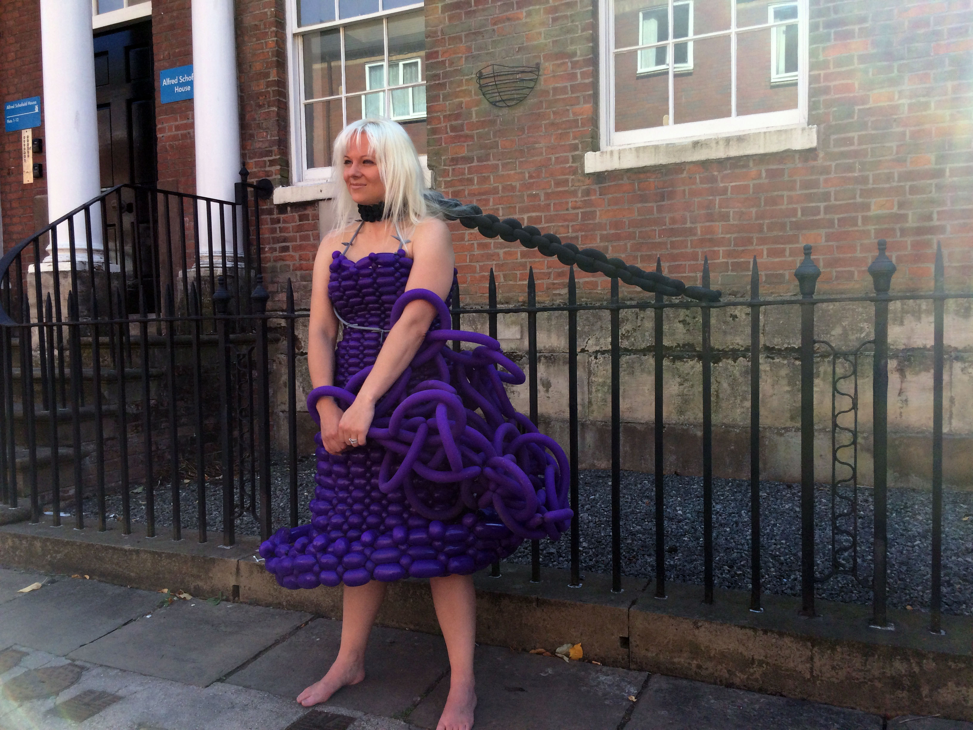 girl in a Freddom festival balloon dress chained to fence with balloon chain