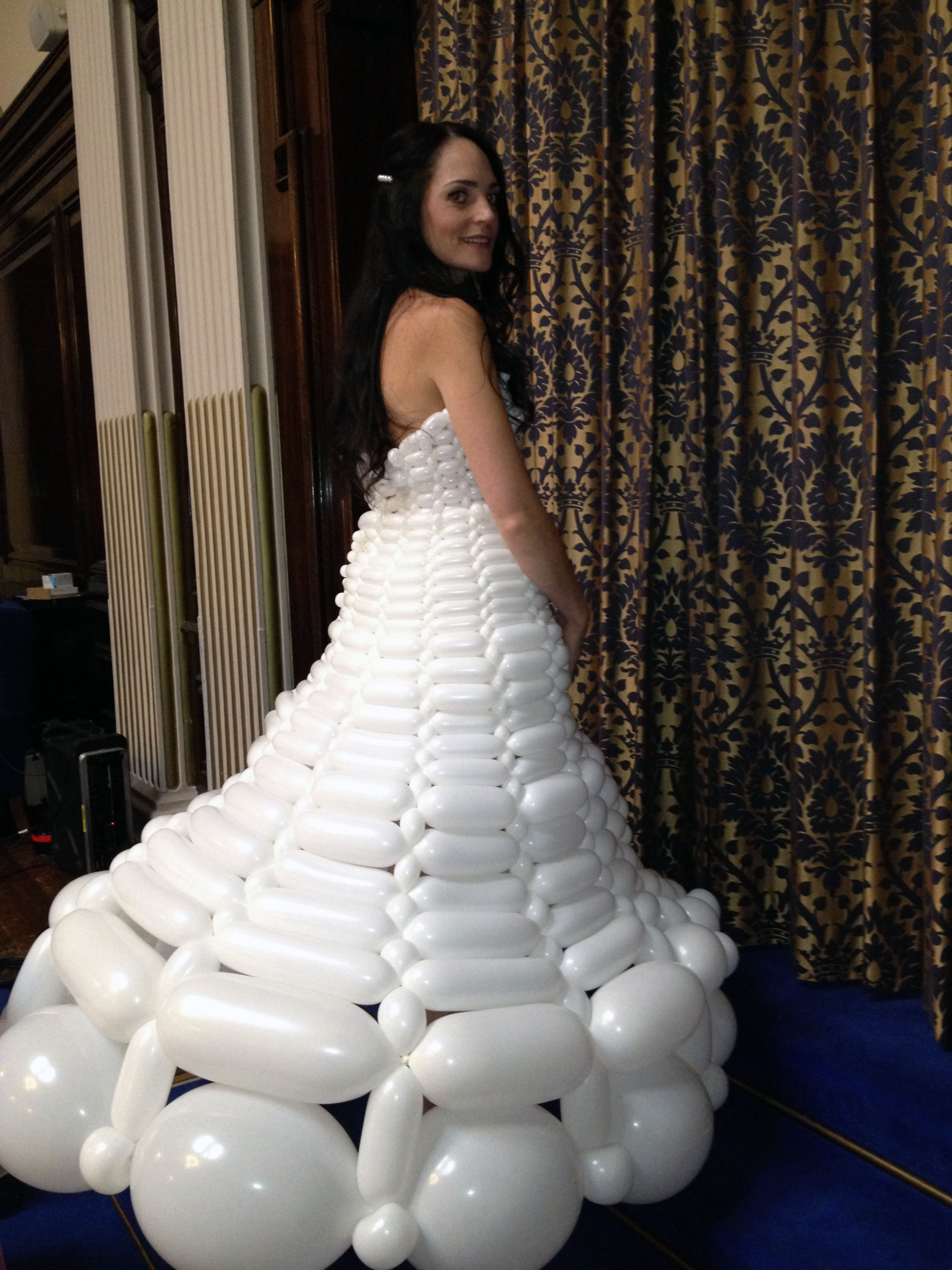 Model wearing a balloon wedding dress waiting to step onto catwalk